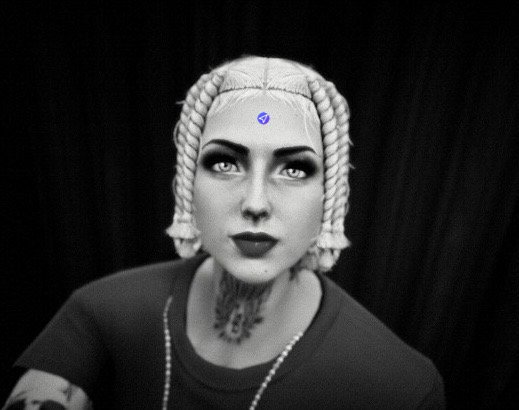 It is a monochromatic (black and white) close-up, photorealistic digital illustration, serving as the cover art for the "AureliaWRLD (Anita Lacey)" Transport Fever mod creator profile on Mod.io. The image is a moody portrait of AureliaWRLD, viewed from a low angle, looking slightly up and directly into the camera with an intense, steady gaze. Her face is centered, and her expression is serious and direct. Her platinum-blonde, braided hair is intricately styled into multiple small cornrows that start at her hairline and curve backward, creating a structured framing effect around her head. Her eyes are dark, intense, and heavily lined, with a prominent white-dot highlight in each, giving her eyes a striking quality. Her lips are full and dark-colored. Extensive, complex black-ink tattoos completely cover her neck and throat, with intricate, symmetrical patterns that wrap around her. Another portion of a tattoo is visible on her left arm in the lower foreground, though partially obscured. She is wearing a simple, dark-colored t-shirt. A textured, multi-link chain necklace hangs around her neck, with some elements visible below her throat. The background is a deeply textured, pitch-black fabric, providing a clean, dramatic negative space to isolate the subject. The lighting is focused and dramatic, highlighting the contours of her face, the details of her hair and tattoos, and the texture of her clothing. A small, blue square Mod.io logo is visible as an overlay in the upper central portion of her forehead, as a unique branding element for the cover art. The overall aesthetic is similar to a high-end, contemporary artist or musician's album cover, combining classical portraiture with modern elements.